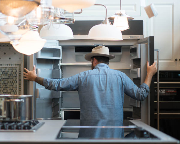 Theron inspecting a refrigerator at a Ferguson Showroom photo
